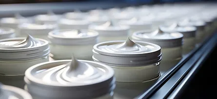 A photo of cosmetic cream on a conveyor belt